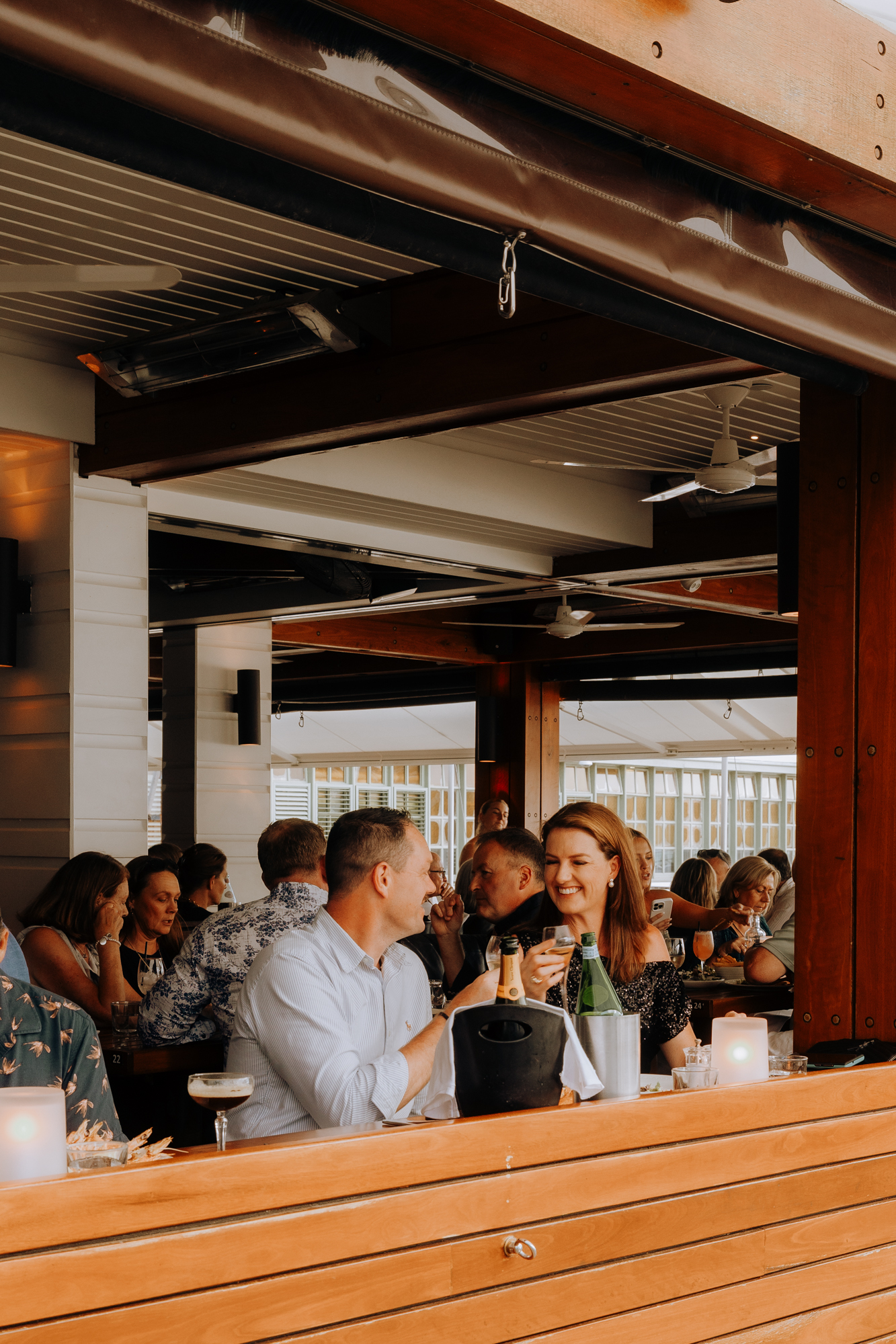 A group of guests raising glasses together at the Hugos Manly bar